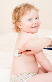 Pediatrician examining little girl with stethoscope