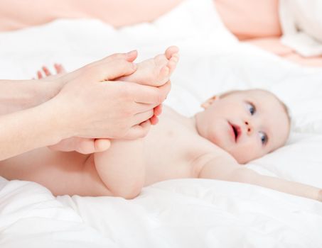 Mother massaging her child's foot, shallow focus