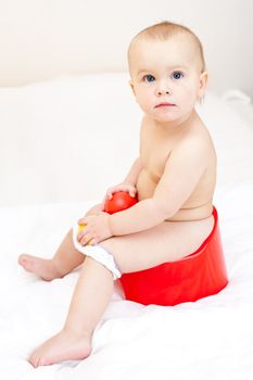Cute little baby girl sitting on red potty