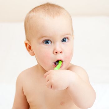 Little baby girl with green tooth brush