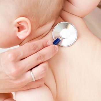 Children's doctor exams infant with stethoscope