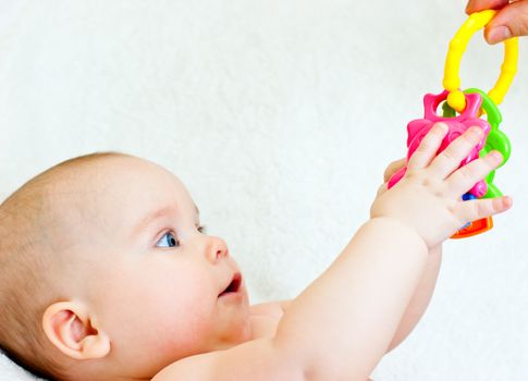 Little baby girl taking teething toy