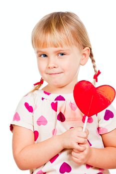 Cute little girl holding big red heart shaped lolly pop candy