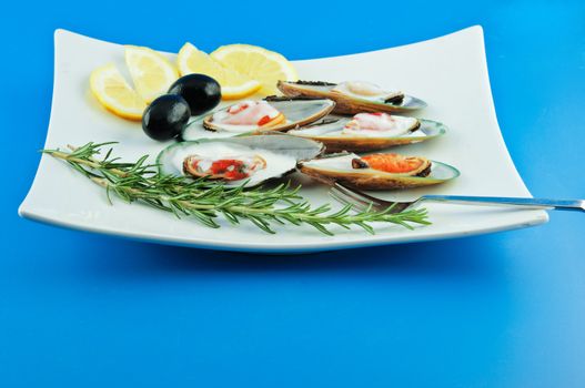 A dish with mussels with milk sauce bechamel with olives, lemon and rosemary