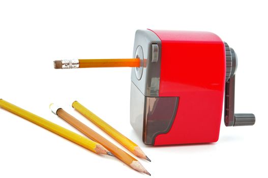 Three yellow pencil and pencil sharpener with a red pencil in