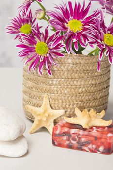 Spa setting with natural soaps and flower on blue strips background