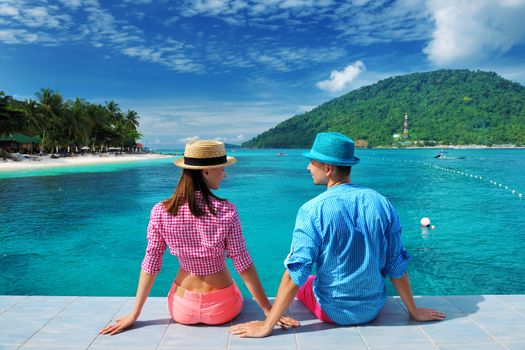 Couple at beach jetty wearing hat