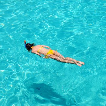 Woman snorkeling in crystal clear turquoise water at tropical beach