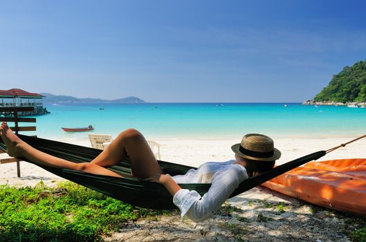 Woman in hammock on tropical beach at Perhentian islands, Malaysia
