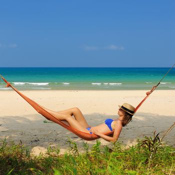 Woman in hammock on tropical beach at Tioman island, Malaysia