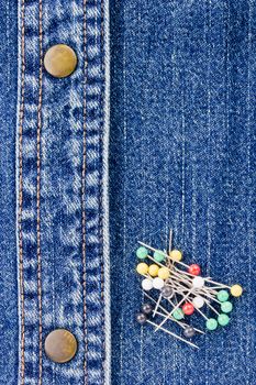 Close-up photograph of pins on denim material.