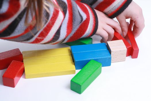 child hands play isolated toy with wooden blocks