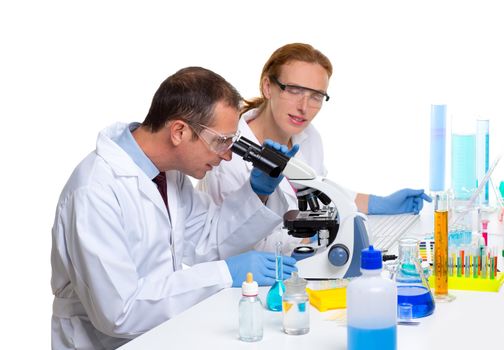 chemical laboratory with two scientist working with test tubes and microscope