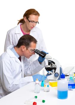 laboratory with two scientist working with test tubes flask and microscope