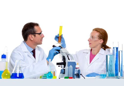 chemical laboratory with two scientist working with test tubes and microscope