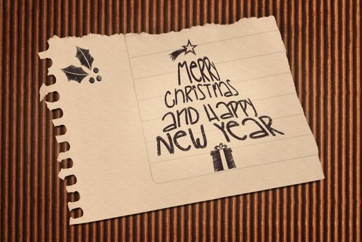 Vintage Merry Christmas and happy new year paper note over corrugated cardboard background. Included clipping path, so you can easily cut it out and place over the top of a design.