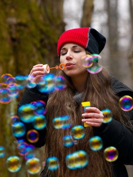 Woman blowing bubbles outdoors