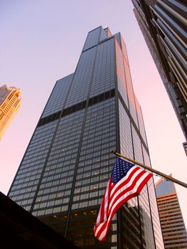Chicago, USA - June 07, 2005: View of the Willis Tower behind an American Flag in Chicago. The building was completed in 1973 and was formerly known as the Sears Tower.