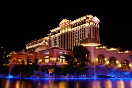Las Vegas, USA - May 22, 2012: Caesars Palace is a hotel and casino that opened in the 1960's in Las Vegas.  One of the many towers of Caesars Palace is seen here at night with Olives restaurant of the neighboring Bellagio Hotel and Casino in the foreground.