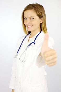 Beautiful blond female doctor showing thumb up smiling happy