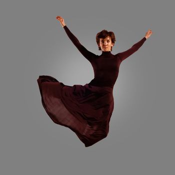 dancer jumping on a gray background, having a fun