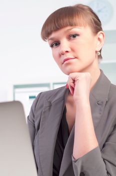 portrait of a beautiful young woman who works at a laptop in the office