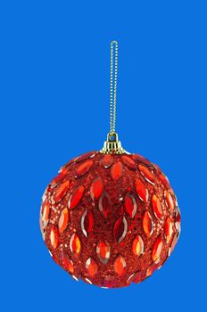 red ball, Christmas decorations hanging on a golden thread against the blue background