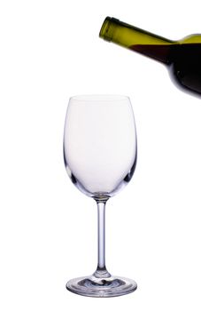 Empty wine glass and bottle of red wine isolated on white background