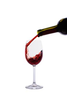 Red wine pouring into wine glass isolated on white background