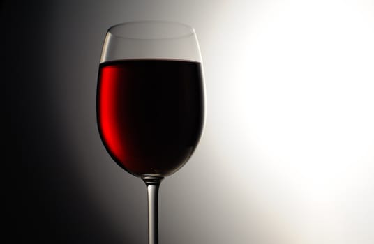 Closeup of red wine wineglass on dark background