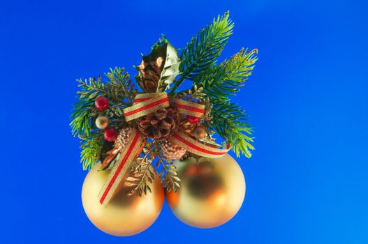 golden balls, cone spruce, fir and sprigs to decorate for Christmas against a blue background