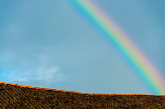 Old roof tiles and rainbow with beautiful blue sky