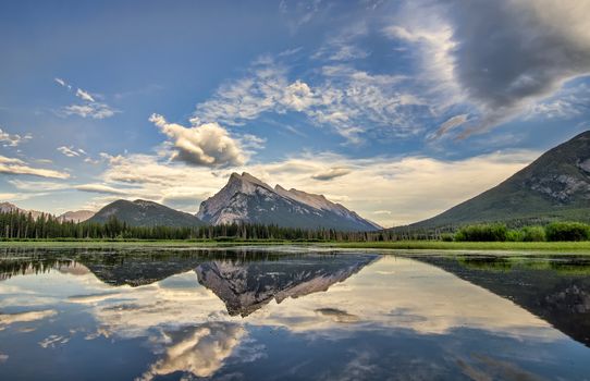 A perfect reflection of the rocky mountains in Vermilion lakes, in Banff National Park Canada.