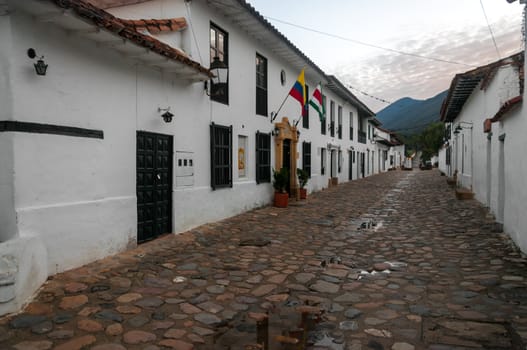 Cobblestone street and old white colonial buildings in Villa de Leyva, Colombia