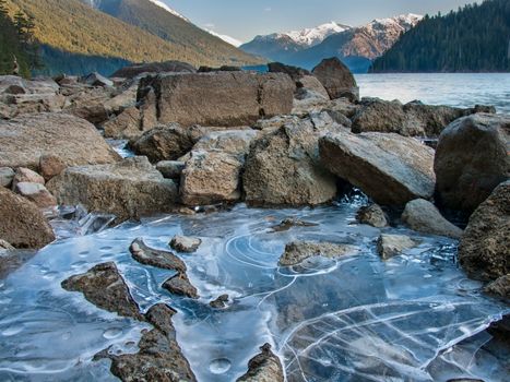 Ice along shore of Cheakamus Lake with mountain in distance