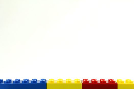 Multi coloured lego wall on white background