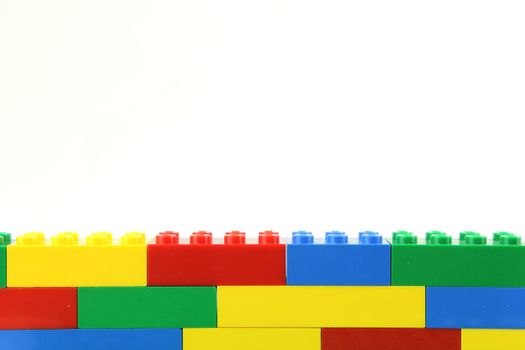 Multi coloured lego wall on white background