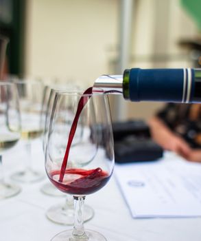 Pouring red wine at a wine tasting