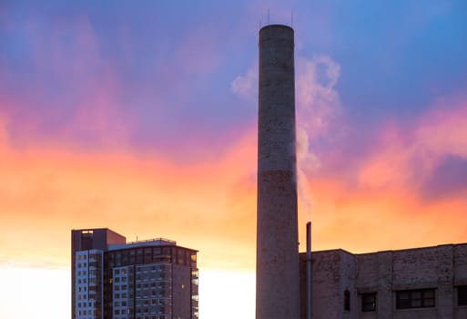 Industrial smokestack with red and blue sunset
