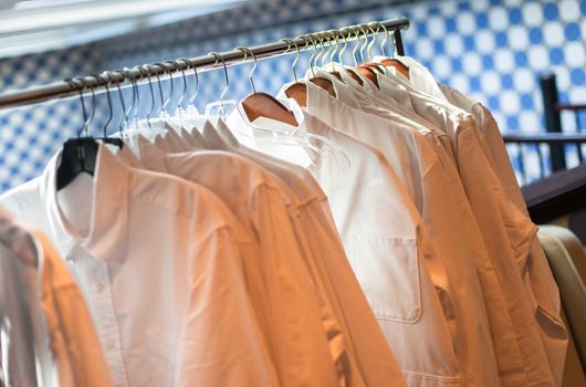 White men's shirts hanging on a rack indoors
