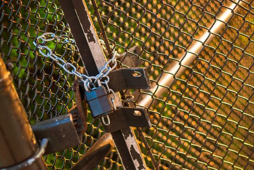 Padlock and chain holding wire fence gate closed