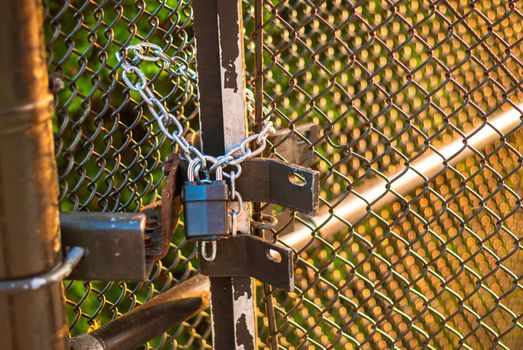 Padlock and chain holding wire fence gate closed