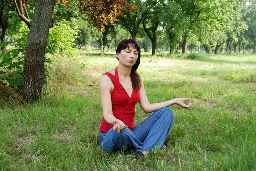 caucasian brunette woman in meditation pose outdoors