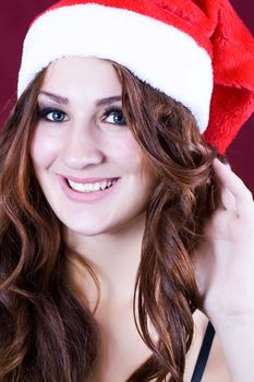 Portrait of a beautiful girl on a red background santa