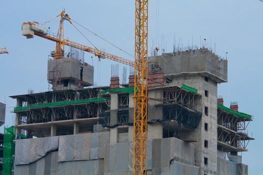 Industrial construction cranes and building at twilight