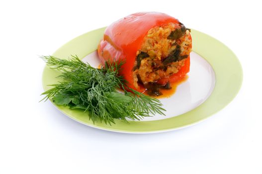 Homemade Red Bell Pepper Filled with Rice, Meat, Onion and Parsley on green plate isolated on white background