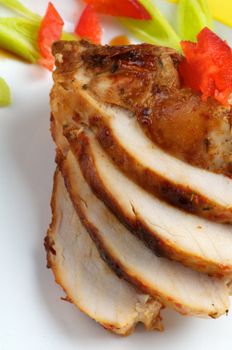 Slices of Grilled Chicken Breast with Vegetables close up on white plate