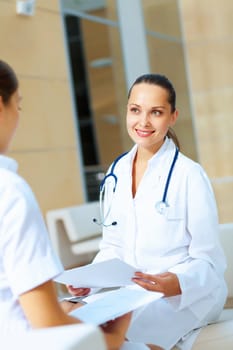 Portrait of two friendly female doctors in hospital discussing something