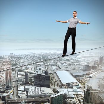 Business woman balancing high over a cityscape