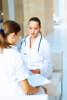 Portrait of two friendly female doctors in hospital discussing something